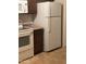Galley kitchen with stove, microwave, refrigerator, and dark wood cabinetry at 440 S Parkcrest -- # 22, Mesa, AZ 85206