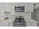 Close-up of stainless steel range and microwave with white cabinetry at 4441 N 27Th Dr, Phoenix, AZ 85017