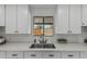 Bright kitchen features white cabinets, modern faucet, undermount sink and a window with a view to the backyard at 4441 N 27Th Dr, Phoenix, AZ 85017