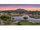 Picturesque community view showcasing a sunset sky, lush landscaping, and a serene pond at 4610 E Meadowview Dr, Gilbert, AZ 85298