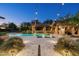 Inviting backyard with sparkling pool, stone patio, cozy gazebo, and ambient string lights at 4610 E Meadowview Dr, Gilbert, AZ 85298
