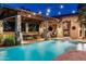 Charming backyard with a pool featuring water features and stone accents, under inviting string lights at 4610 E Meadowview Dr, Gilbert, AZ 85298