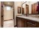 Bathroom vanity with granite countertop, wooden cabinets, and tile flooring, next to walk-in shower at 4610 E Meadowview Dr, Gilbert, AZ 85298