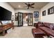 Living room featuring a leather couch, desk, and doors to the backyard and tile floors at 4610 E Meadowview Dr, Gilbert, AZ 85298