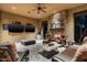 Spacious covered patio with stone fireplace, ceiling fan, and comfortable lounge area at 4610 E Meadowview Dr, Gilbert, AZ 85298