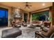 Covered patio featuring a stone fireplace, comfortable seating, and open views of the backyard at 4610 E Meadowview Dr, Gilbert, AZ 85298