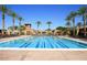 Large community pool with lap lanes, palm trees, lounge seating, and well-maintained landscaping at 4610 E Meadowview Dr, Gilbert, AZ 85298
