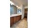 Bathroom showcasing a double sink vanity, warm wood tones, and a walk-in closet at 5345 W Marcus Dr, Phoenix, AZ 85083