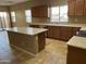 Spacious kitchen with an island, wooden cabinets, stainless steel appliances, and large windows at 5345 W Marcus Dr, Phoenix, AZ 85083