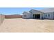 Large empty backyard with stucco walls and sliding glass doors leading to a new construction home at 5614 W Saint Moritz Ln, Glendale, AZ 85306