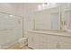 This bright bathroom features a double sink vanity, neutral counter tops, tiled shower with glass door and updated fixtures at 5614 W Saint Moritz Ln, Glendale, AZ 85306