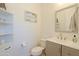 This powder bathroom offers a gray vanity, neutral counter top, decorative mirror and beach themed wall art at 5614 W Saint Moritz Ln, Glendale, AZ 85306