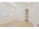 Minimalist bedroom with a ceiling fan, tile floors, two windows, and an open closet at 5614 W Saint Moritz Ln, Glendale, AZ 85306