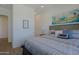 Bedroom with a wood-framed bed, serene wall art, plush pillows, and soft, patterned bedding at 5614 W Saint Moritz Ln, Glendale, AZ 85306