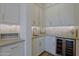Bright butler's pantry featuring white cabinetry, a prep sink, and a built-in wine refrigerator at 5614 W Saint Moritz Ln, Glendale, AZ 85306