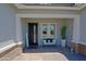 Cozy covered front porch with striped bench, decorative plant and owl figurine, and a modern black front door at 5614 W Saint Moritz Ln, Glendale, AZ 85306