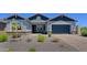Well maintained front yard with gravel landscaping leading up to a cozy covered porch with a two car garage to the right at 5614 W Saint Moritz Ln, Glendale, AZ 85306