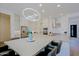Spacious kitchen with white cabinets, a large island with seating, stainless steel appliances, and modern lighting fixtures at 5614 W Saint Moritz Ln, Glendale, AZ 85306