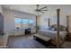 Main bedroom featuring wood-look tile floors, abundant natural light, and four-poster bed at 5614 W Saint Moritz Ln, Glendale, AZ 85306