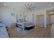 Main bedroom showcasing wood-look tile floors, abundant natural light, and four-poster bed at 5614 W Saint Moritz Ln, Glendale, AZ 85306