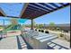 Modern outdoor kitchen featuring a built-in grill, counter space and an adjacent playground under a stylish pergola at 5614 W Saint Moritz Ln, Glendale, AZ 85306