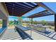 Community outdoor kitchen featuring dual grills, sink, dining table, and shade under a pergola at 5614 W Saint Moritz Ln, Glendale, AZ 85306