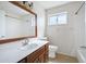 Traditional bathroom vanity with wood cabinets, sink, and a large mirror at 6128 W Columbine Dr, Glendale, AZ 85304