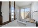 Bright bathroom with a built-in tub, tile surround, and natural light from windows to the backyard at 6128 W Columbine Dr, Glendale, AZ 85304