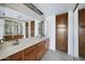 Bathroom featuring a dual sink vanity with ample storage space and large mirror at 6128 W Columbine Dr, Glendale, AZ 85304