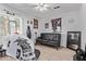 Converted bedroom space, featuring barber's chair, sofa, tile floors, and a ceiling fan at 6814 W Berkeley Rd, Phoenix, AZ 85035