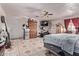 Open bedroom with ceiling fan, tile flooring, exercise equipment, and a walk-out door at 6814 W Berkeley Rd, Phoenix, AZ 85035