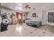 Open bedroom with ceiling fan, tile flooring, exercise equipment, and a walk-out door at 6814 W Berkeley Rd, Phoenix, AZ 85035