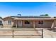 Single-story home featuring solar panels, fenced front yard, neutral paint, and covered entry at 6814 W Berkeley Rd, Phoenix, AZ 85035