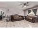 Cozy living room with tile flooring, ceiling fan, dark drapery, and decorative sofas at 6814 W Berkeley Rd, Phoenix, AZ 85035