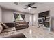 Cozy living room with tile flooring, ceiling fan, dark drapery, and decorative sofas at 6814 W Berkeley Rd, Phoenix, AZ 85035