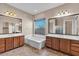 Luxurious bathroom with dual vanities, a soaking tub, and ample lighting at 6886 W Mazatzal Dr, Peoria, AZ 85383