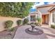 Charming courtyard featuring a water fountain, brick pavers, and lush landscaping at 6886 W Mazatzal Dr, Peoria, AZ 85383