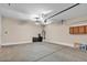 Large open garage space features painted concrete floor and basic utility lighting at 6886 W Mazatzal Dr, Peoria, AZ 85383