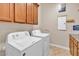 Spacious laundry room features cabinets above a full-size washer and dryer at 6886 W Mazatzal Dr, Peoria, AZ 85383
