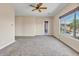 Cozy living room with ceiling fan, carpet, and bright window views to backyard at 6886 W Mazatzal Dr, Peoria, AZ 85383