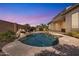 Private backyard pool with rock waterfall feature and lush tropical landscaping under a twilight sky at 6886 W Mazatzal Dr, Peoria, AZ 85383