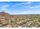 Expansive aerial view showcasing the community with mature landscaping, red tile roofs and stunning mountain views at 7134 E Sandia St, Mesa, AZ 85207