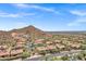 Expansive aerial view showcasing the community with mature landscaping, red tile roofs and stunning mountain views at 7134 E Sandia St, Mesa, AZ 85207