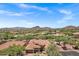Expansive aerial view displays the neighborhood's layout, lush desert landscaping, and stunning mountain scenery at 7134 E Sandia St, Mesa, AZ 85207
