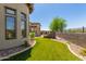 Spacious backyard with artificial grass, manicured landscaping, and a covered patio area at 7134 E Sandia St, Mesa, AZ 85207
