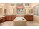 Bright bathroom with a large soaking tub, dual vanities, and plenty of light at 7134 E Sandia St, Mesa, AZ 85207