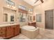 Elegant bathroom with a soaking tub, dual vanities, and glass block window at 7134 E Sandia St, Mesa, AZ 85207