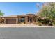 Charming stone home featuring a tile roof, two-car garage, and beautiful landscaping at 7134 E Sandia St, Mesa, AZ 85207