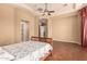 Spacious bedroom featuring tray ceilings, fan, wood floors, and hallway at 7134 E Sandia St, Mesa, AZ 85207