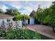 Lush backyard featuring verdant landscaping, flowers, and an outbuilding at 7214 E Royal Palm Rd, Scottsdale, AZ 85258